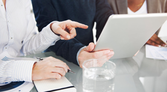 Two People Sitting in an Office, Discussing While Looking at a Tablet