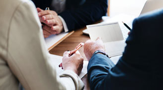 Hands Holding a Pen and a paper on a Table